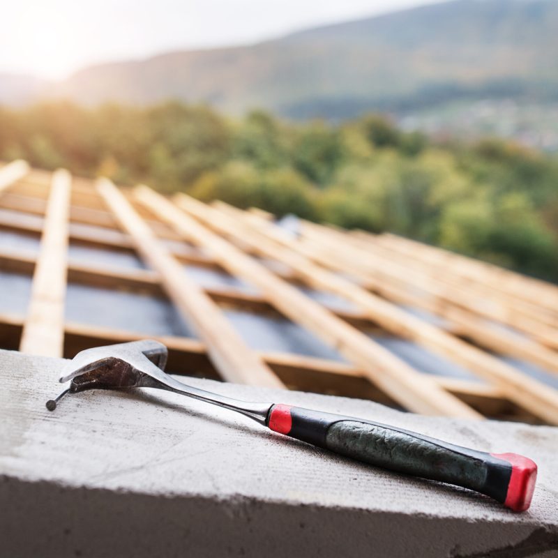 Hammer on the roof on the construction site.