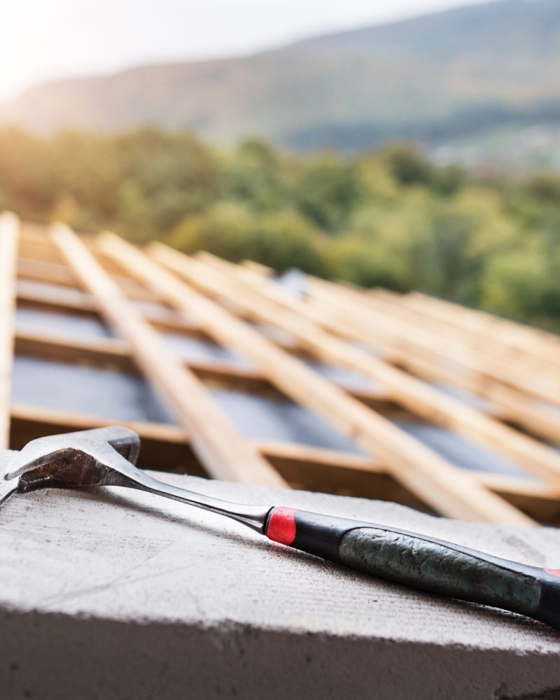 Hammer on the roof on the construction site.