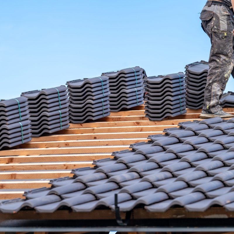 craftsman laying fired ceramic tiles on the roof