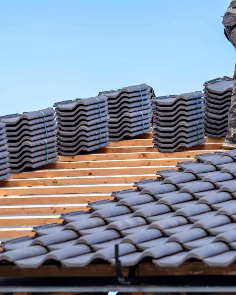craftsman laying fired ceramic tiles on the roof