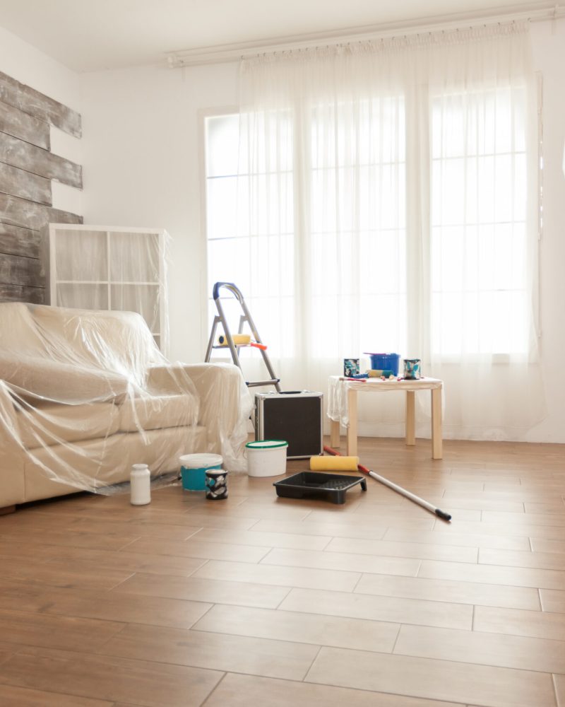 Apartment with nobody in it ready for professional renovation. Plastic sheet. Home during renovation, decoration and painting. Interior apartment improvement maintenance. Roller, ladder for house repair