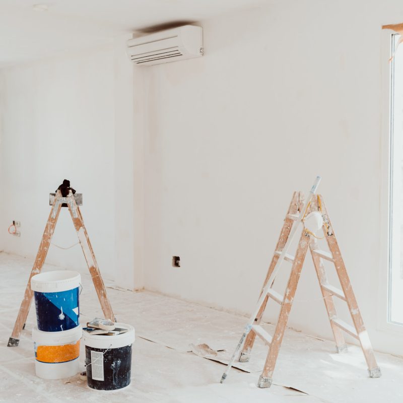 ladders and pots on white room at construction site. Painting wa