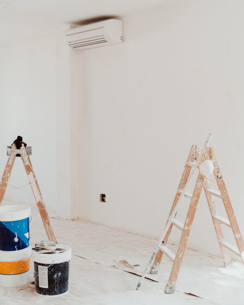 ladders and pots on white room at construction site. Painting wa